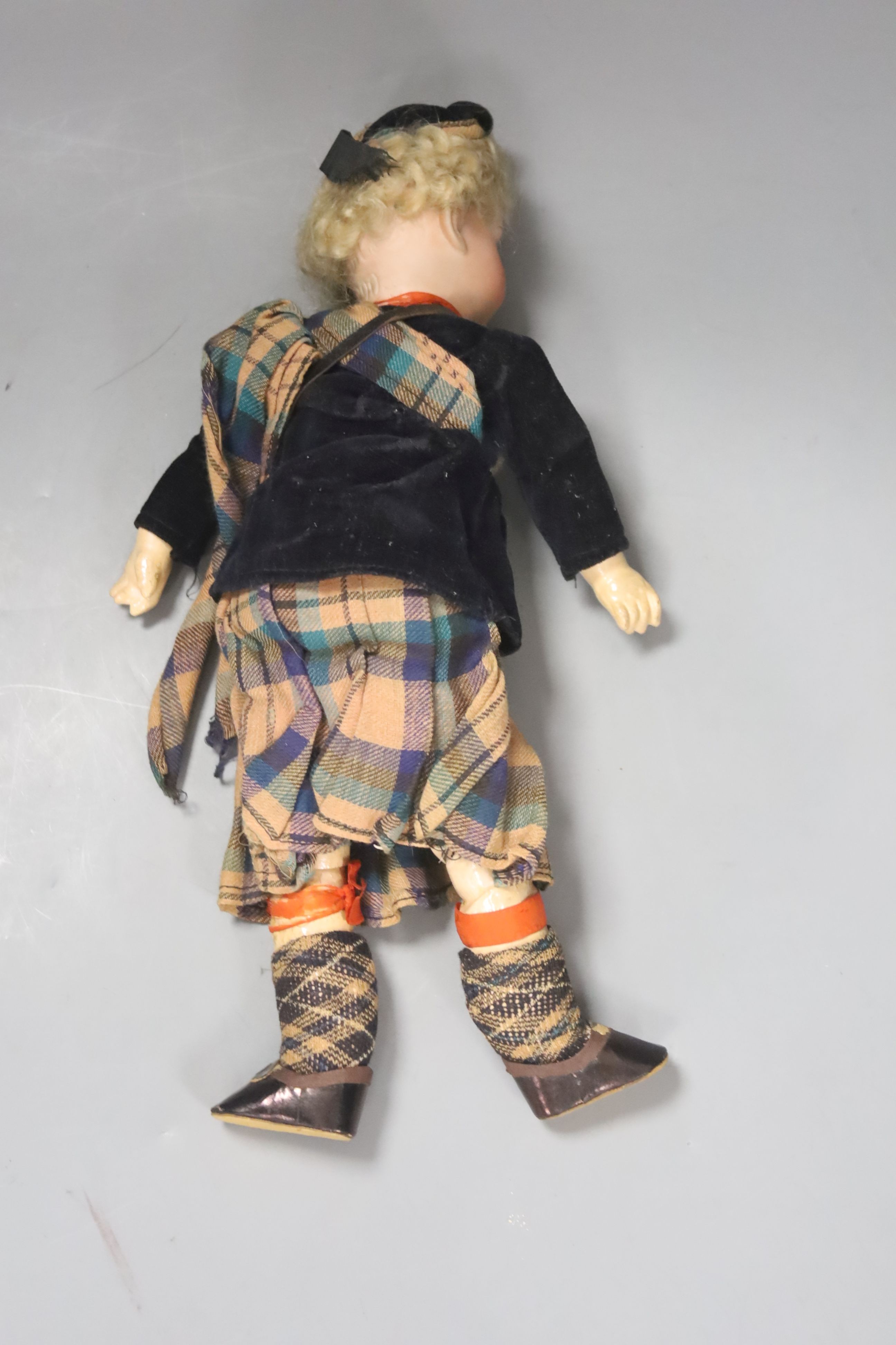 An AM bisque doll, Scottish dress. 30cm